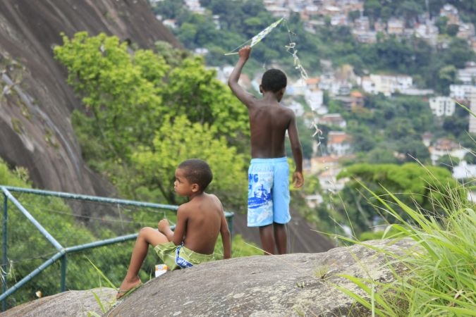 Foto de duas crianças com pipa no alto do morro (Sônia Fleury)